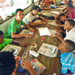 Boys putting together the newspaper bags